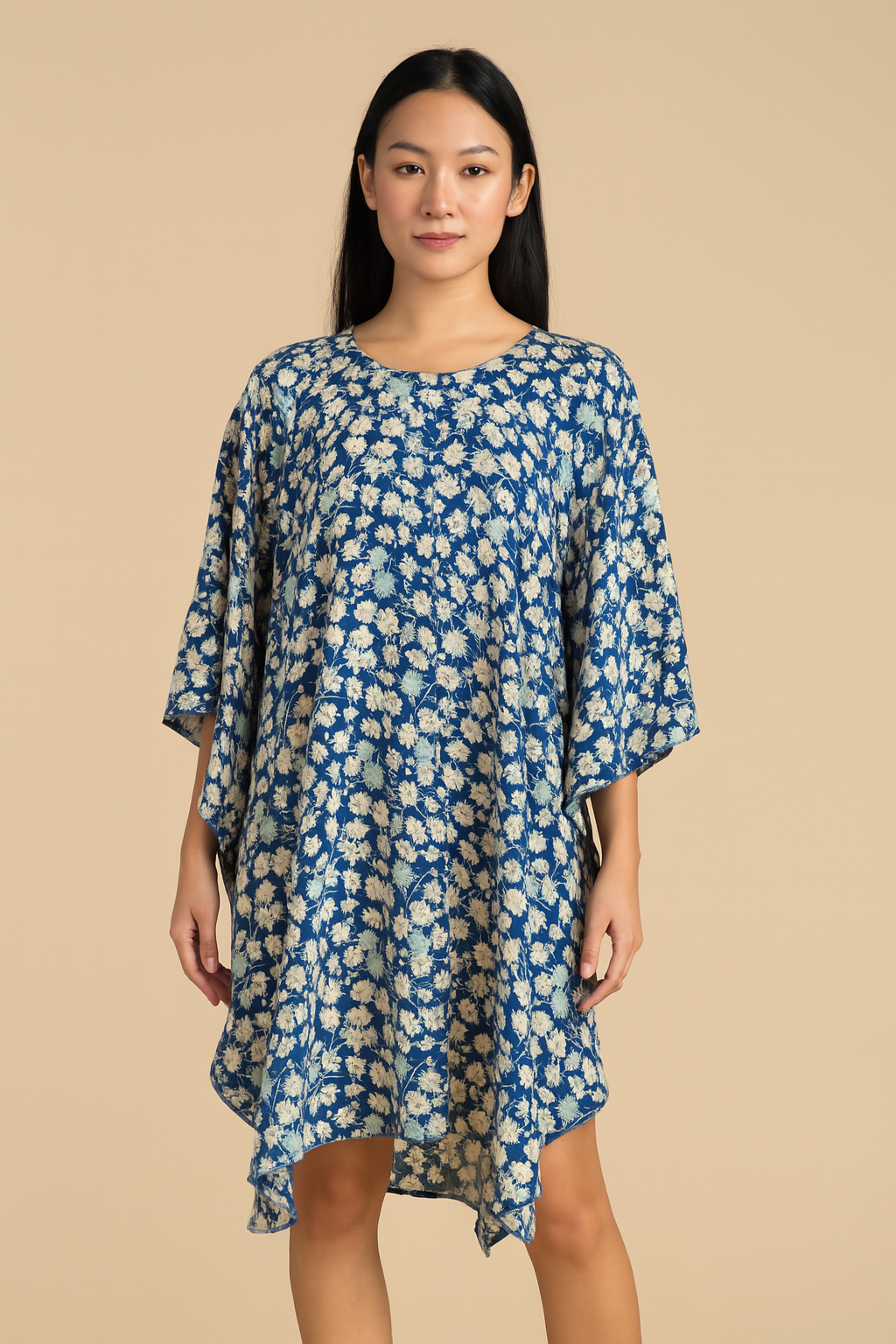 Woman wearing a blue floral dress against a beige background