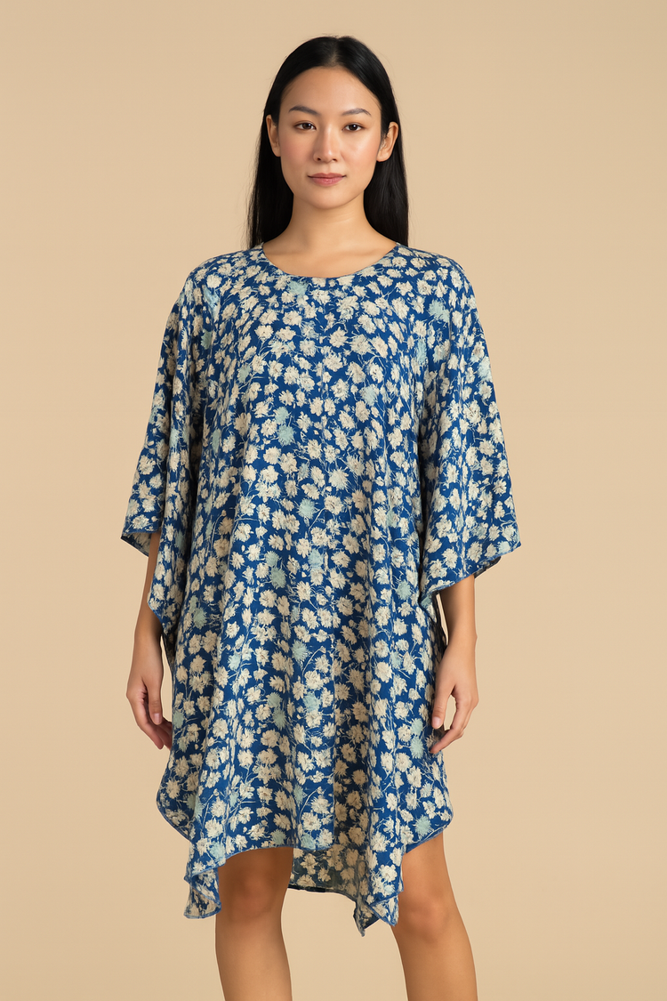 Woman wearing a blue floral dress against a beige background
