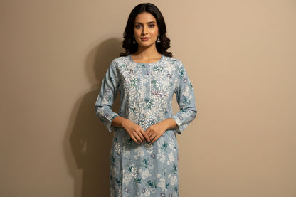 Floral patterned dress on a mannequin against a beige wall.