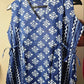 Blue and white patterned dress on a hanger against a beige background