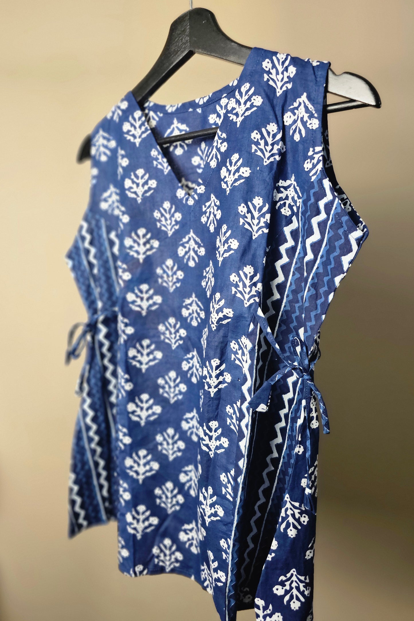 Blue and white patterned fabric on a hanger against a beige background