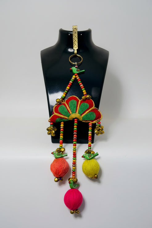 Colorful traditional hip danglers with hanging beads on a mannequin bust.