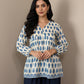 Mannequin wearing a blue and white patterned sweater against a brown background