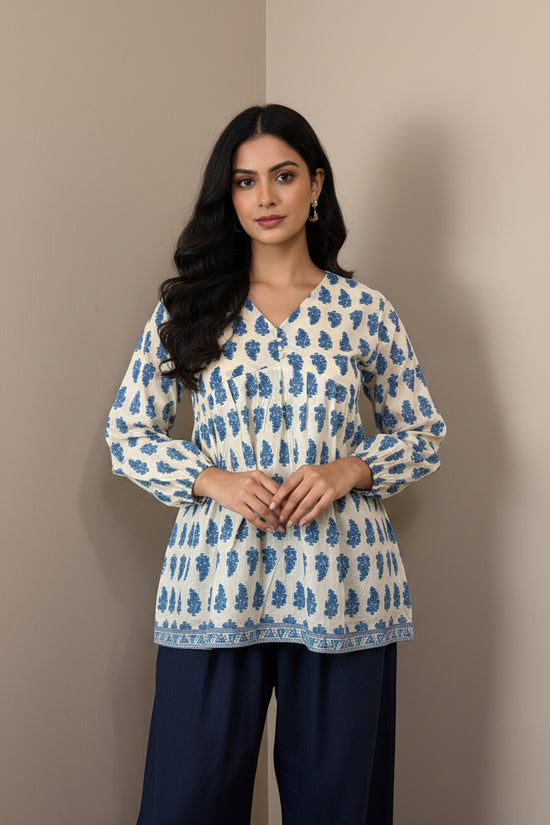 Mannequin wearing a blue and white patterned sweater against a brown background