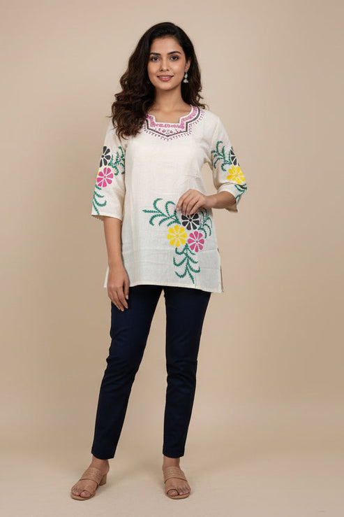 Beige blouse with floral embroidery on a mannequin against a plain background
