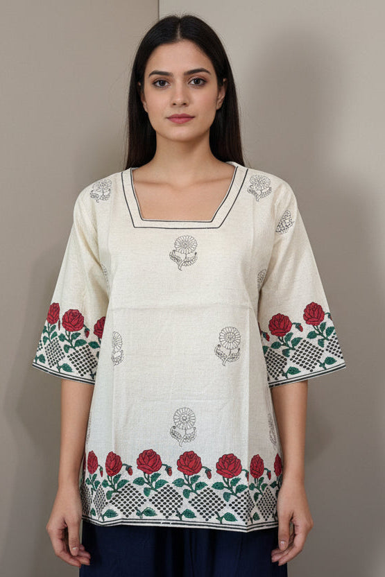 Traditional outfit with embroidered top and navy pants on a mannequin against a plain background