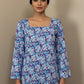 Mannequin wearing a floral-patterned blouse with long sleeves against a plain background