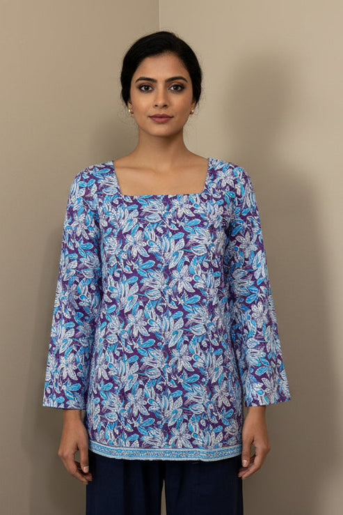Mannequin wearing a floral-patterned blouse with long sleeves against a plain background