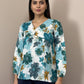 Mannequin wearing a floral top and dark pants against a neutral background