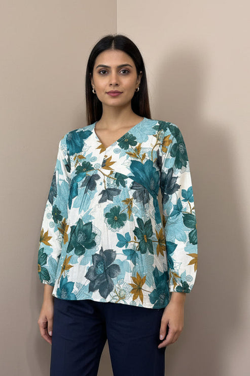 Mannequin wearing a floral top and dark pants against a neutral background