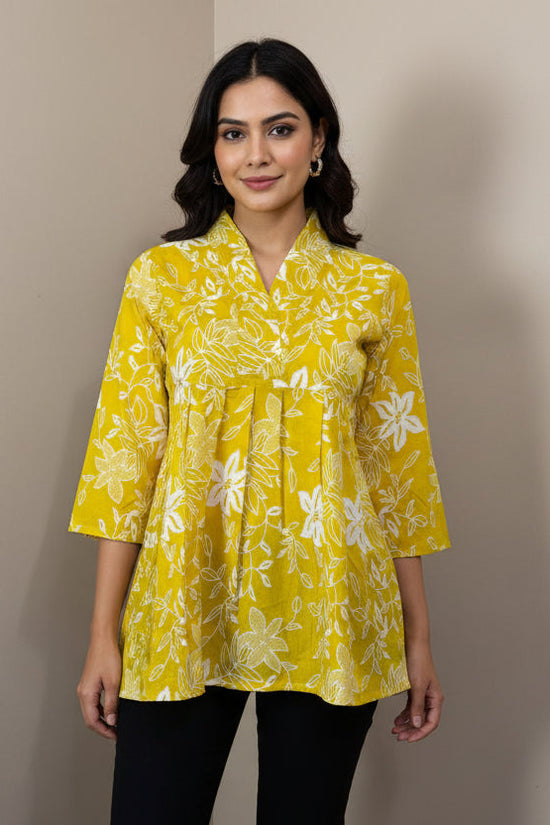 Yellow floral blouse on a mannequin against a plain background