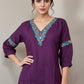 Purple top with colorful embroidery on a mannequin against a beige background