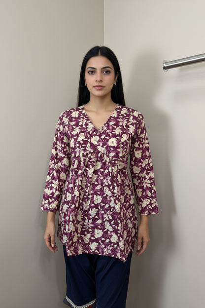 Mannequin wearing a purple floral long-sleeve top against a neutral background