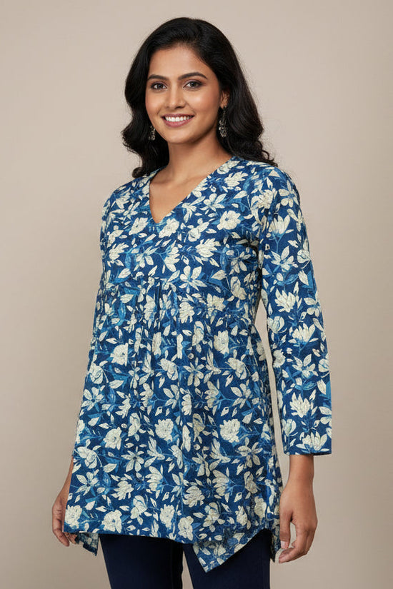 Mannequin wearing a blue floral blouse with navy pants against a beige background