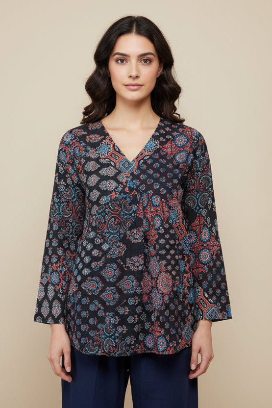 Mannequin wearing a patterned top and navy pants against a beige background