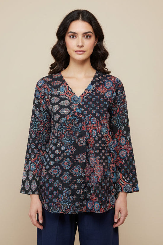 Mannequin wearing a patterned top and navy pants against a beige background