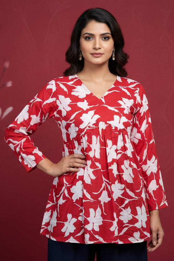 Red floral top with white flowers on a mannequin against a neutral background