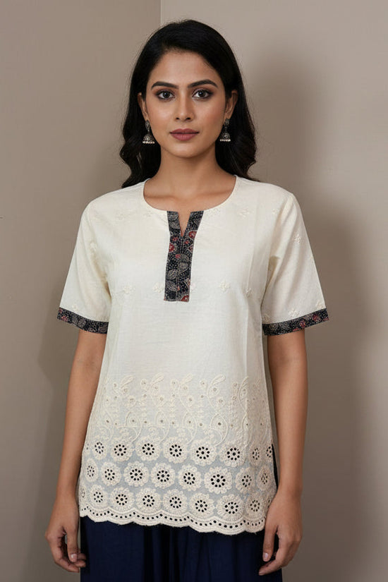 Beige lace top on a mannequin against a plain background