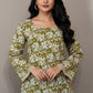 Green floral blouse with navy pants on a mannequin against a gray background