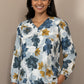 Floral blouse on a mannequin against a beige background