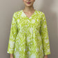 Green floral blouse on a mannequin against a brown background