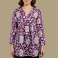 Mannequin wearing a purple and white floral top with navy pants on a beige background