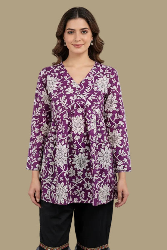 Mannequin wearing a purple and white floral top with navy pants on a beige background