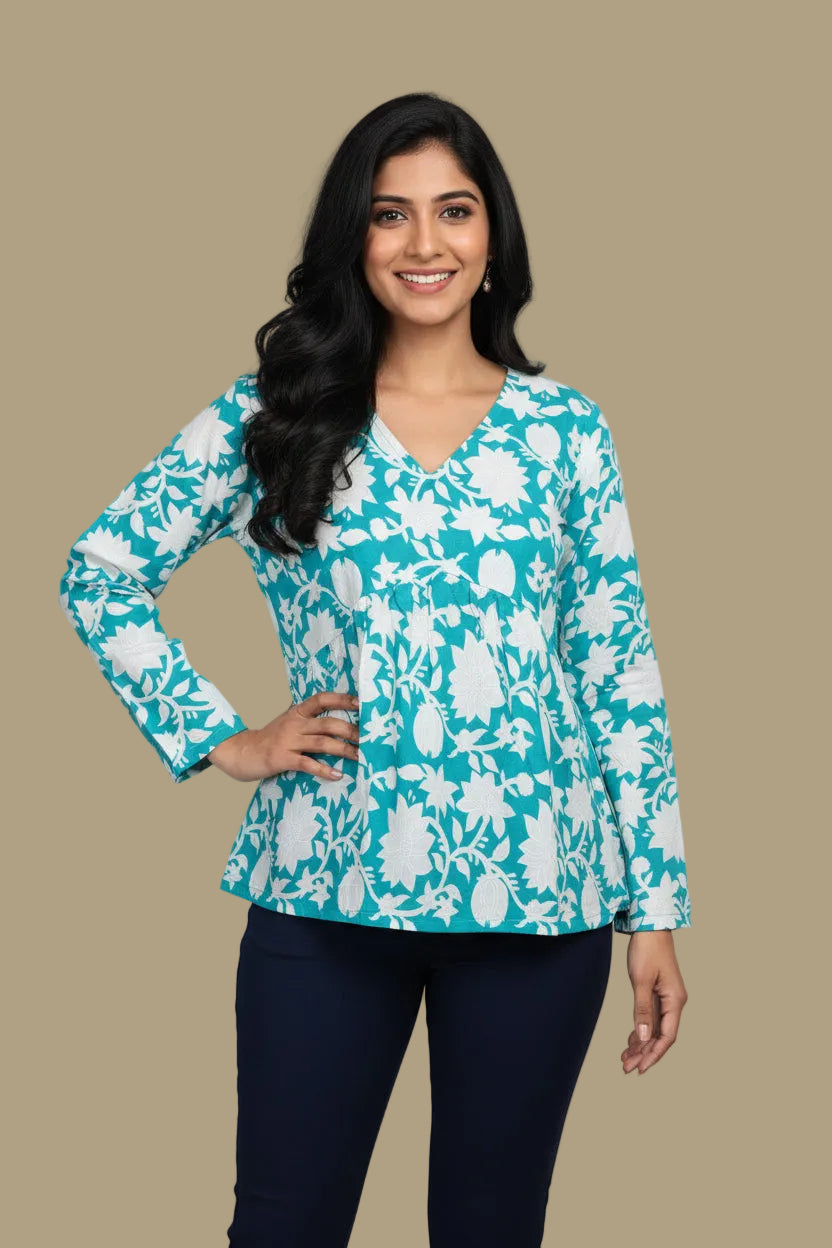 Teal floral top and navy pants on a mannequin against a beige background