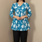 Blue floral top with white flowers on a mannequin against a beige background